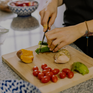 Close-up of a chef cutting fresh fruits and vegetables to illustrate the tasty, balanced food options The Abbey Retirement Living Community offers residents.