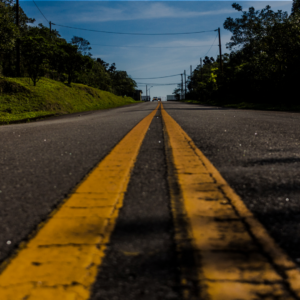 Close up image of double yellow line on a roadway to illustrate the various transportation options available to those living at The Abbey Retirement Living Community.